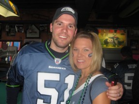 Man in blue Seahawks jersey 51 smiling in bar